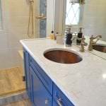 blue bathroom cabinetry and metal sink