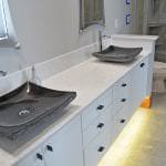 White vanity cabinet with black vessel sinks