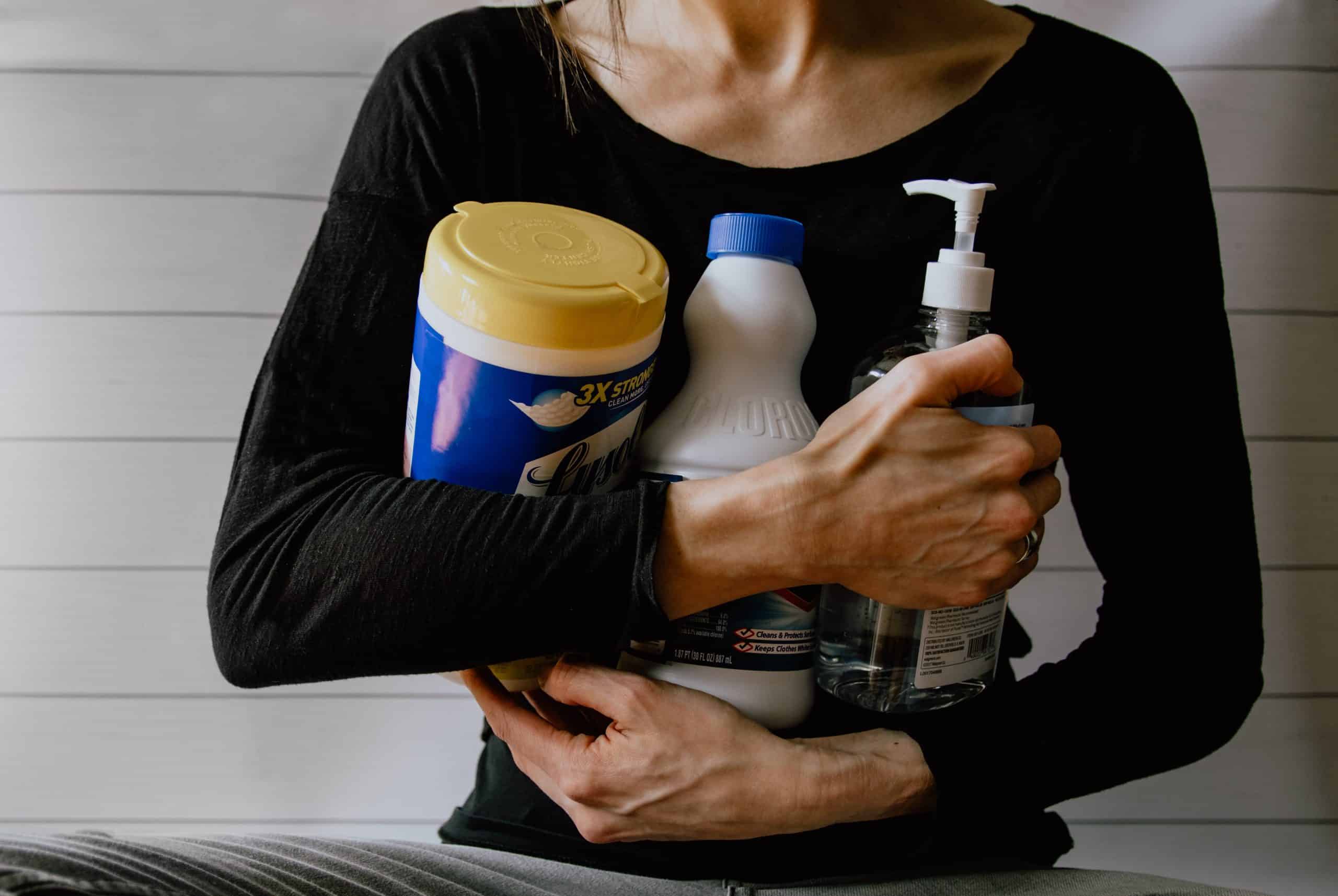 woman holding cleaning products