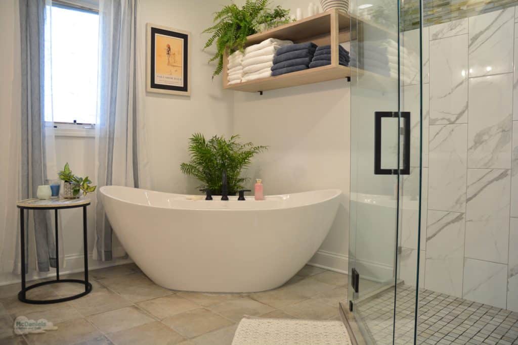 bath design with freestanding tub and open shelves