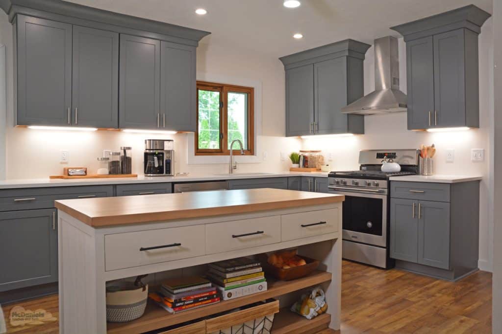gray and white kitchen design with open shelves in the island
