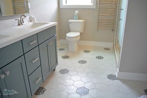 bathroom design with gray vanity and hexagonal floor tile