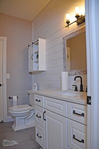 bathroom with vanity and over the toilet storage
